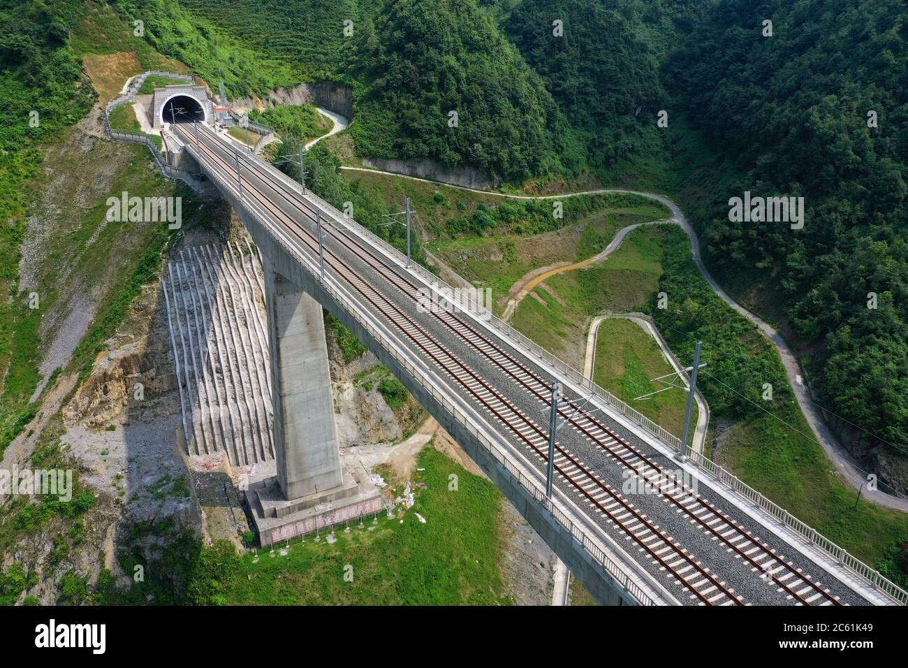 Liupanshui. 6th July, 2020. Aerial photo taken on July 6, 2020 shows a railway bridge along the Anshun-Liupanshui railway in southwest China's Guizhou Province. The Anshun-Liupanshui intercity railway, with a designed speed of 250 km per hour, is being prepared for opening. The railway will shorten the travel time between Guiyang and Liupanshui from the current 3.5 hours to about 1 hour, and Liupanshui City will be fully connected with the national high-speed rail network. Credit: Liu Xu/Xinhua/Alamy Live News Stock Photo