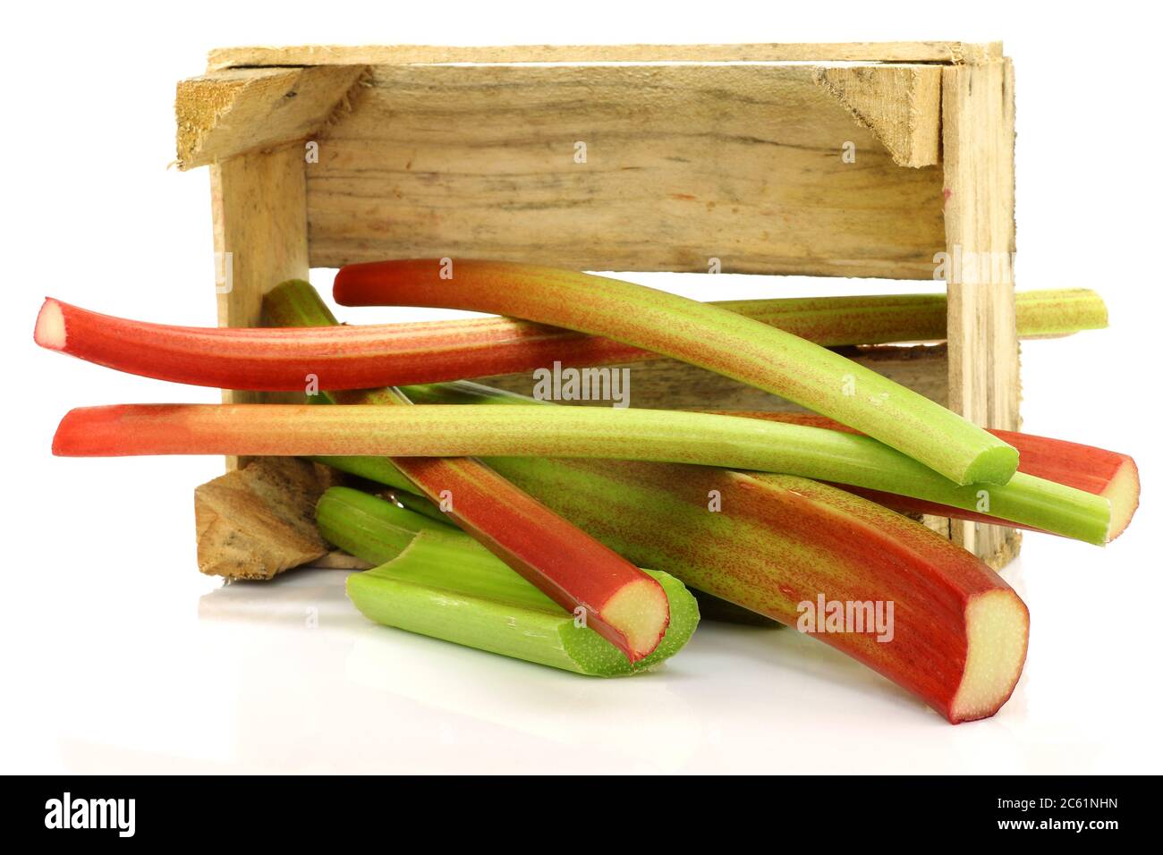 fresh stems of rhubarb in a wooden box on a white background Stock Photo