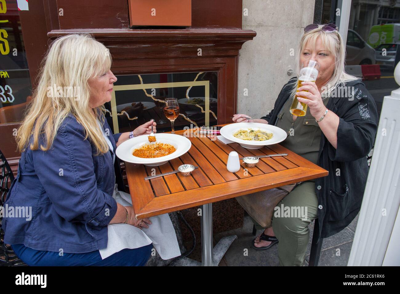 Glasgow, Scotland, UK. 6th July, 2020. Pictured: People out enjoying a meal and a drink in the middle of Glasgow Centre in the warm sunshine. From today Pubs, bars, cafes and restaurants in England, Scotland and Northern Ireland are welcoming customers for the first time since lockdown began in March. Credit: Colin Fisher/Alamy Live News Stock Photo