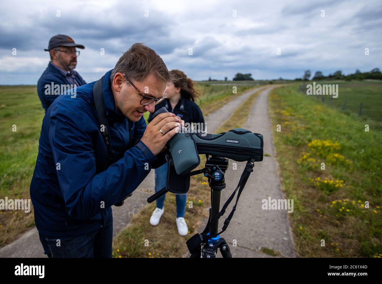 02 July 2020, Mecklenburg-Western Pomerania, Greifswald: Patrick Dahlemann (SPD), Parliamentary State Secretary for Western Pomerania, observes rare water birds on the island trail to the nature conservation island Koos in the Greifswald Bodden. After the renaturation, animal and plant species that were thought to be lost have returned to the island in recent years. The Succow Foundation was established in 1999 as the first non-profit nature conservation foundation in the new German states. In 2016 it took over 365 hectares on the island and in the Karrendorf meadows on the mainland. Photo: Je Stock Photo