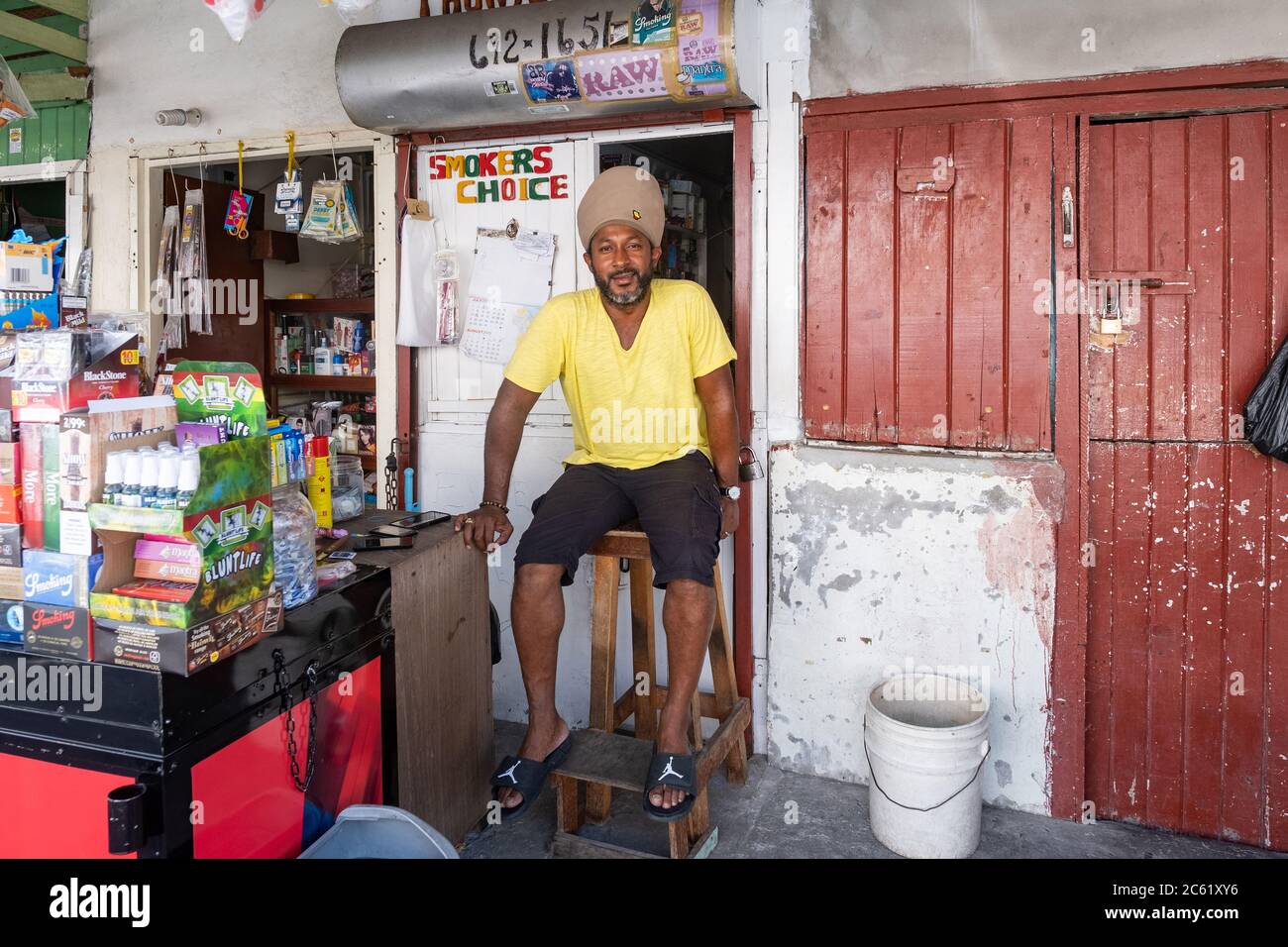 Rastafari shopkeeper / Rasta vendor selling groceries in shopping street in the city Georgetown, Demerara-Mahaica region, Guyana, South America Stock Photo