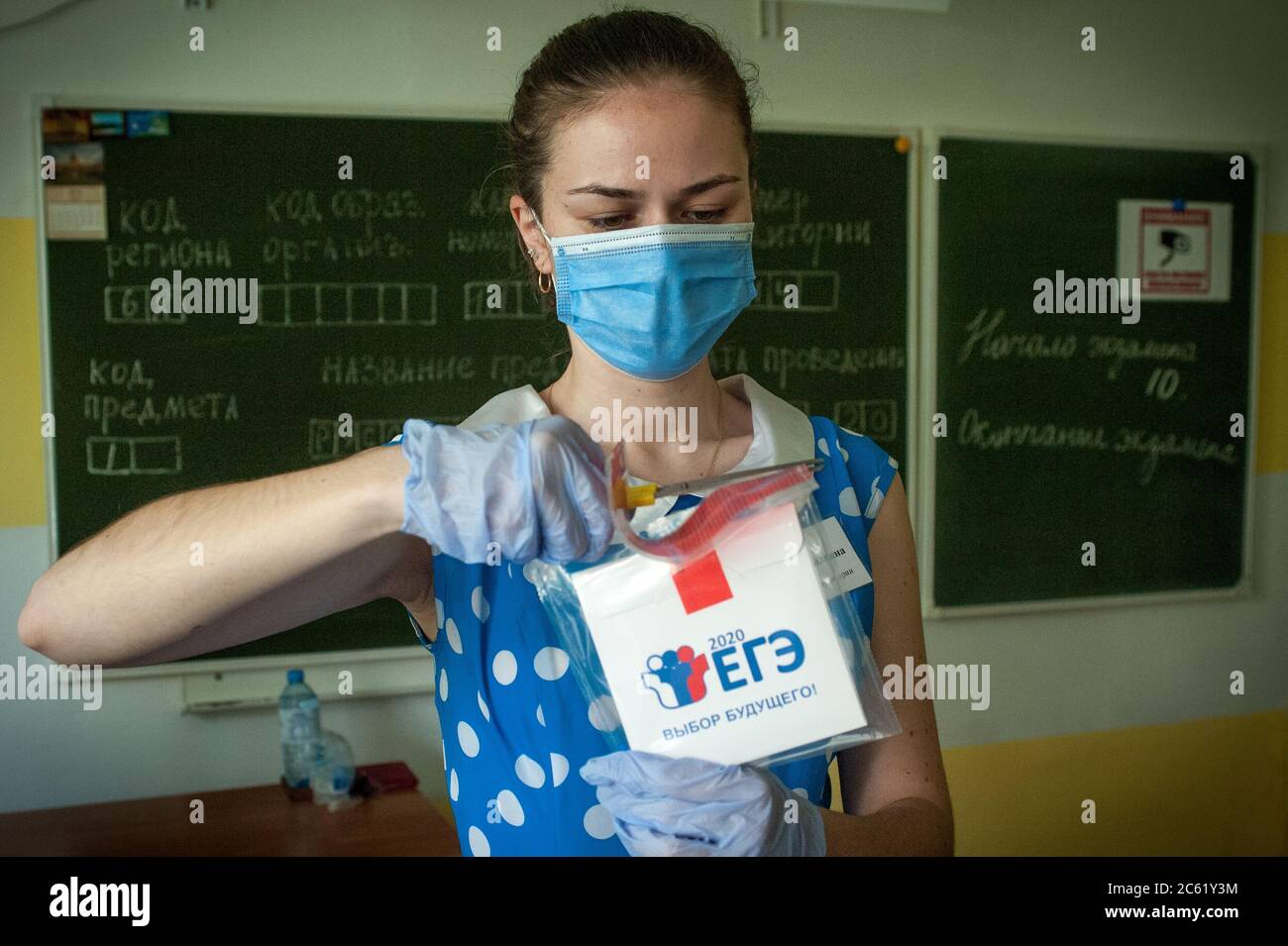 A worker in the audience at the gymnasium No.12 in Tambov opens a safe-bag with examination materials.Students of Tambov (Russia) pass the Unified State Final Examinations in the Russian language. Stock Photo
