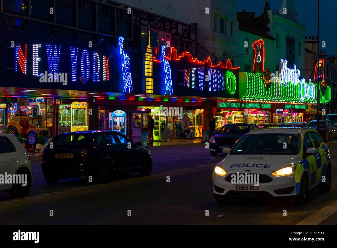 Police car patrolling amusement arcades illuminated along Marine Parade, Southend on Sea, Essex, UK. Night Stock Photo