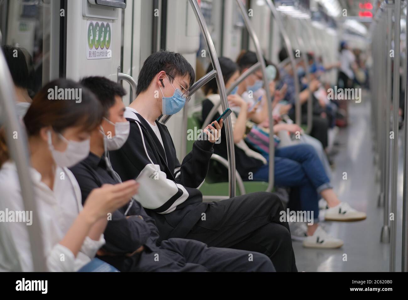 To prevent infection of coronavirus COVID-19, passengers wearing surgical mask sitting in subway train in China . Stock Photo
