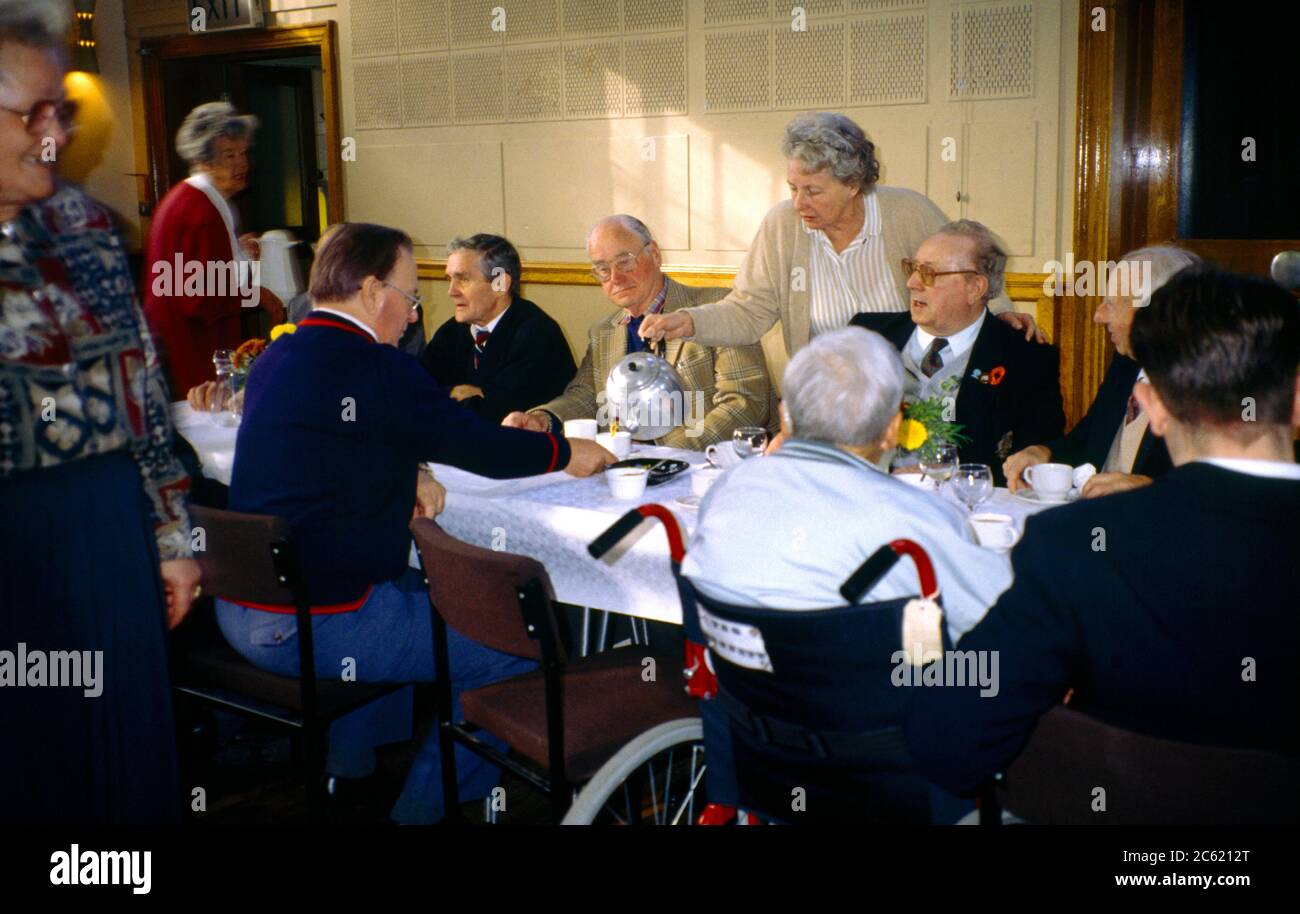 Lest We Forget Association Volunteer Workers Serving Coffee to Group of Senior Citizens Stock Photo