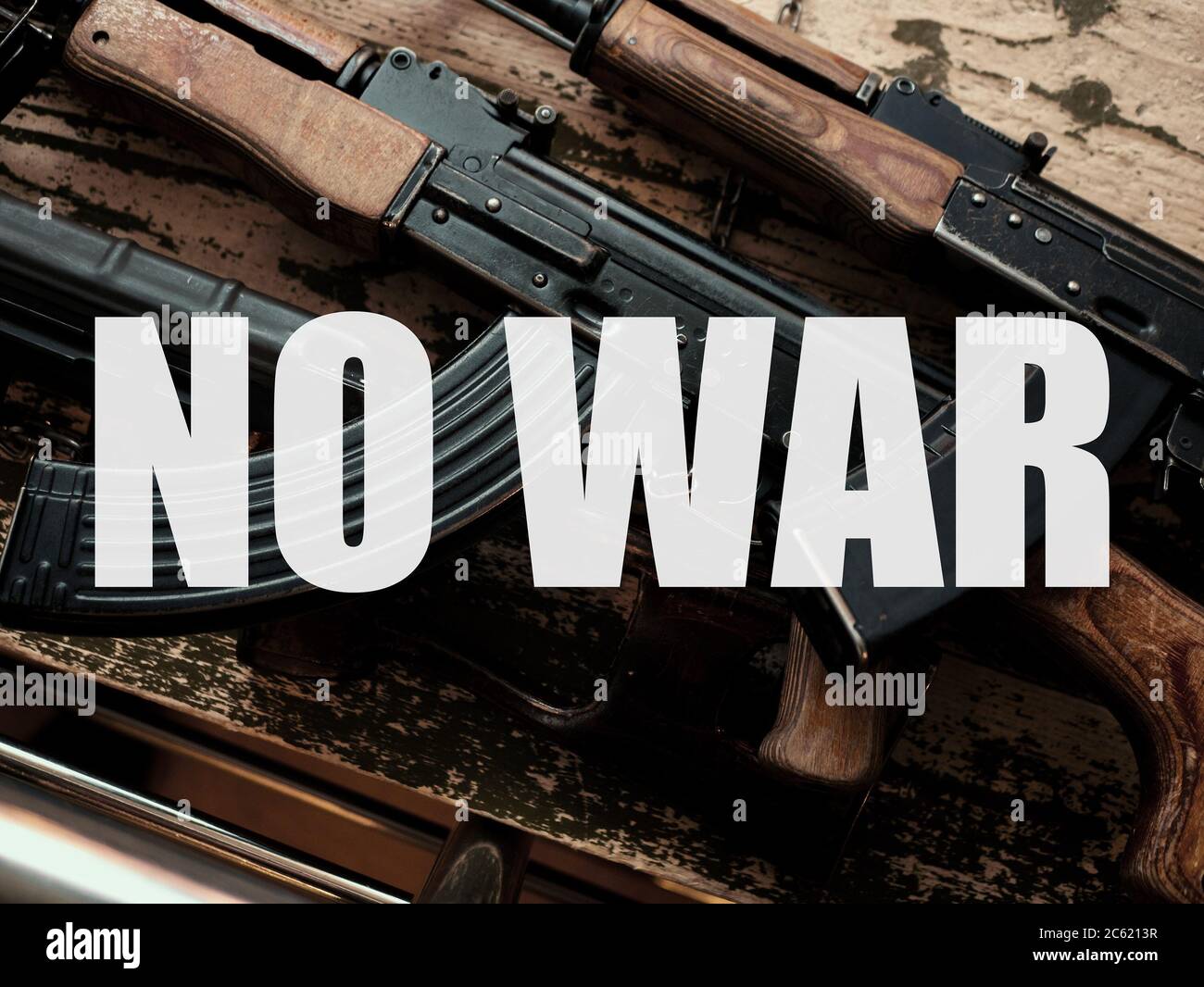 NO WAR - text over military guns on vintage grunge background. Peace in world concept against armed conflicts. Stock Photo