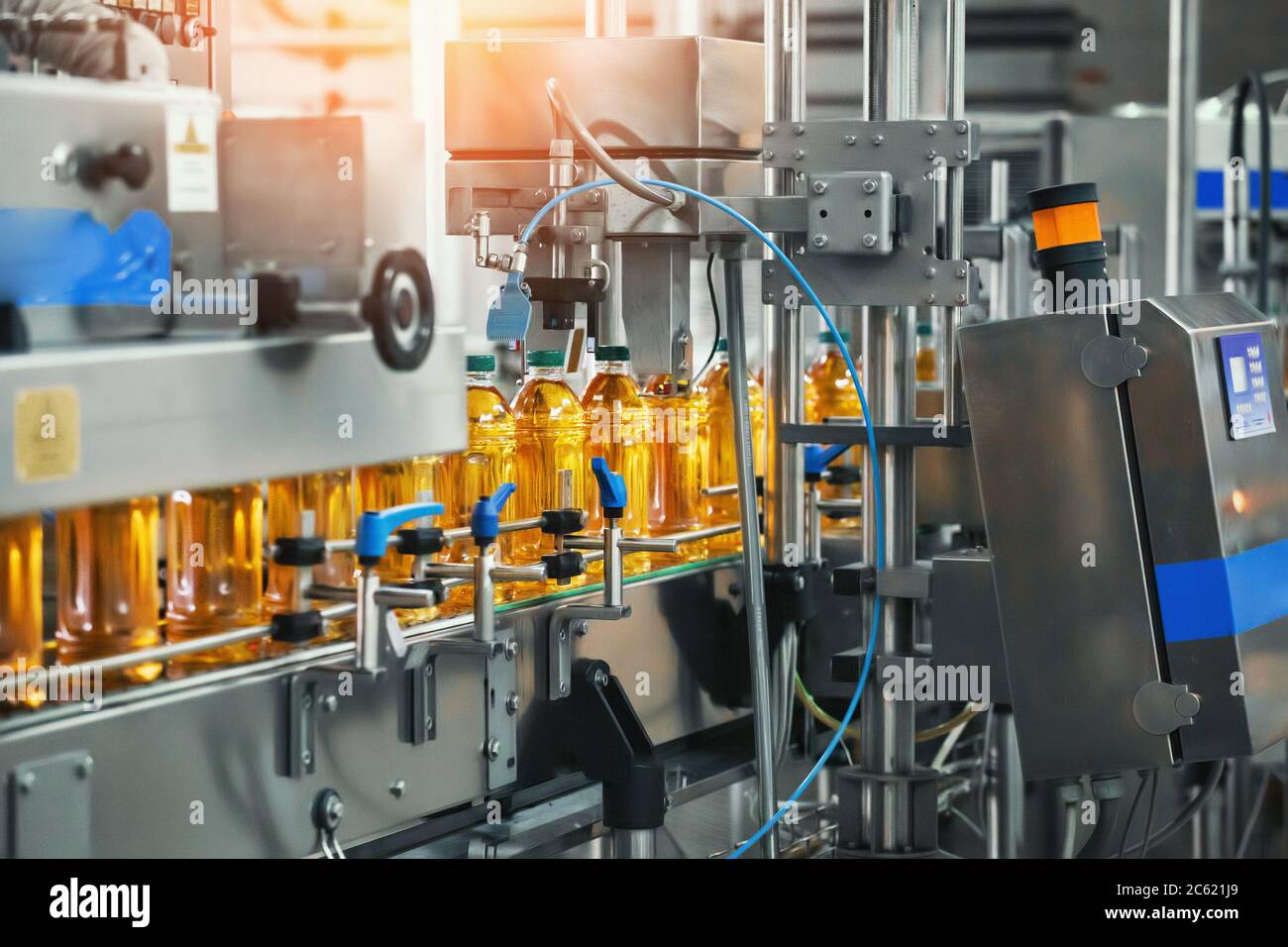 Juice in bottles on Conveyor belt, beverage factory interior, industrial production line. Stock Photo