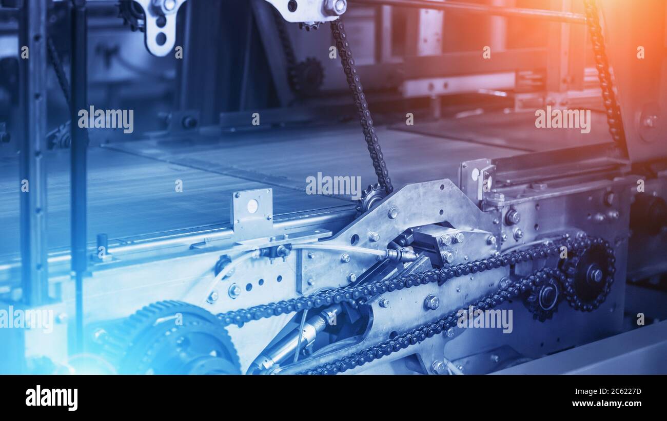 Industry background, empty industrial Conveyor belt with metal chains and mechanisms in blue color and red and blue light effects, copy space for text. Stock Photo