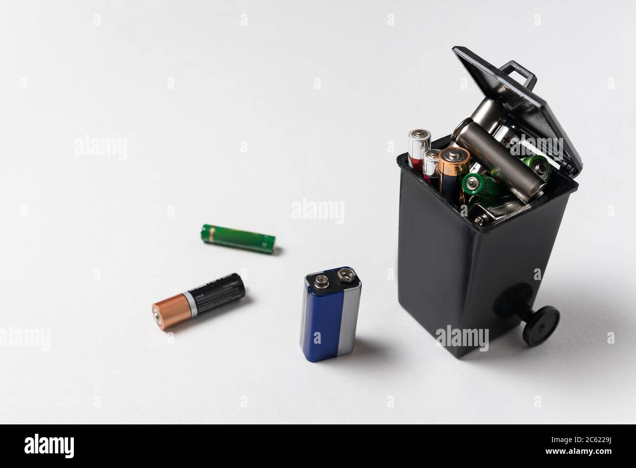 Used batteries in the garbage container on white background. Electronic