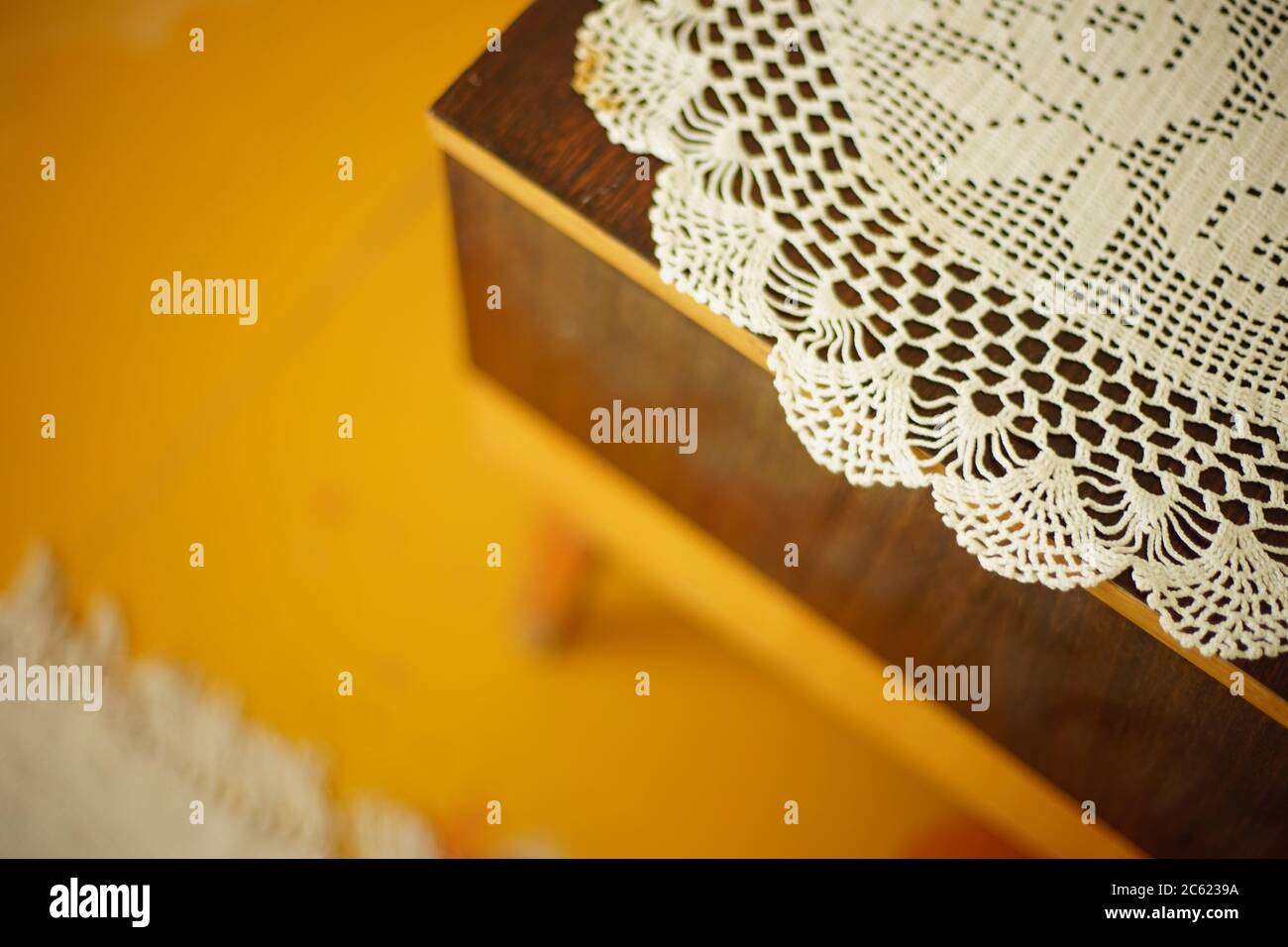crocheted white doily on the bedside table Stock Photo