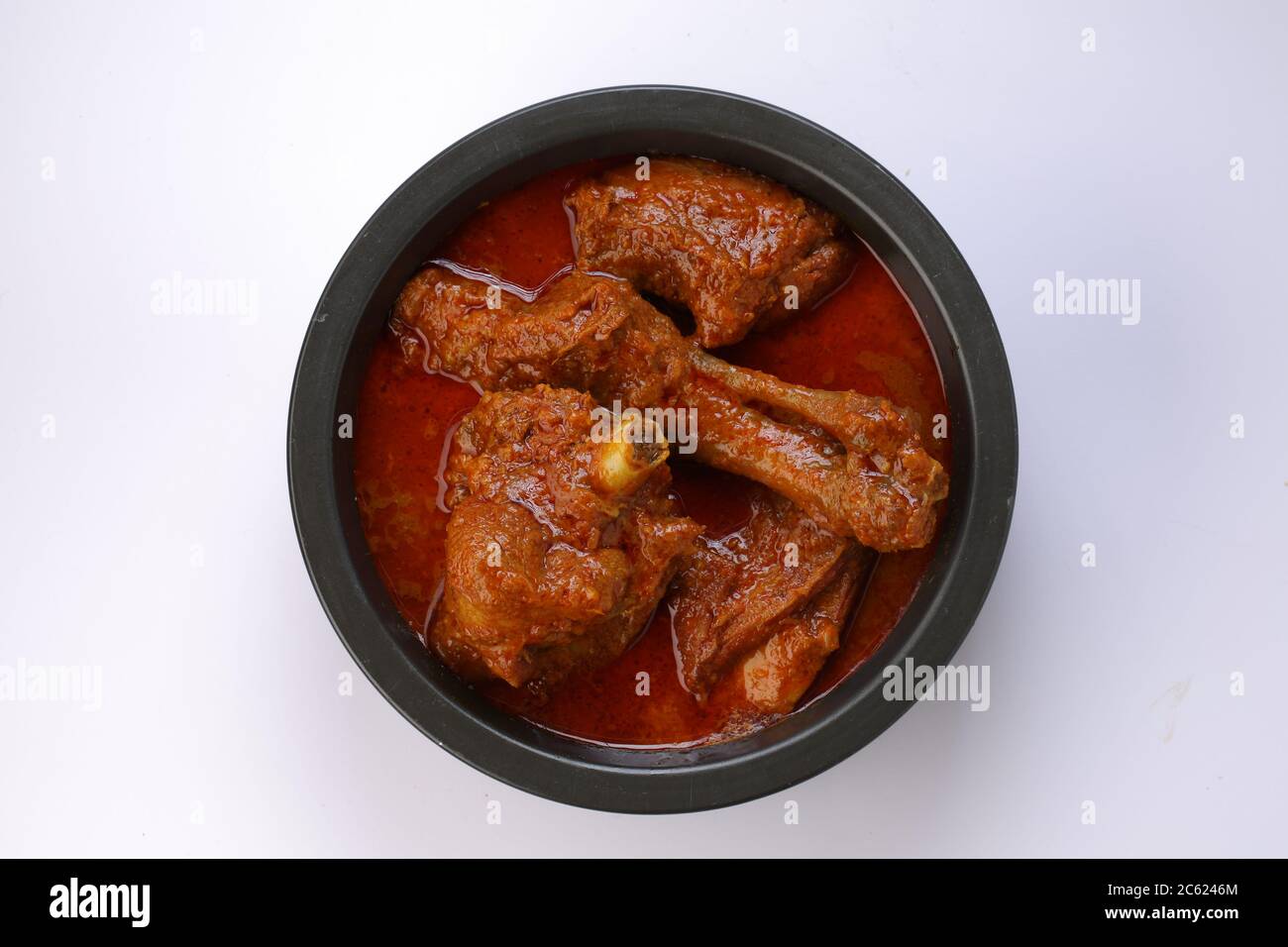 Topview of Mutton curry or Lamb curry,spicy and delicious dish arranged in a black vessel with white texture or background,an ideal combination for ap Stock Photo