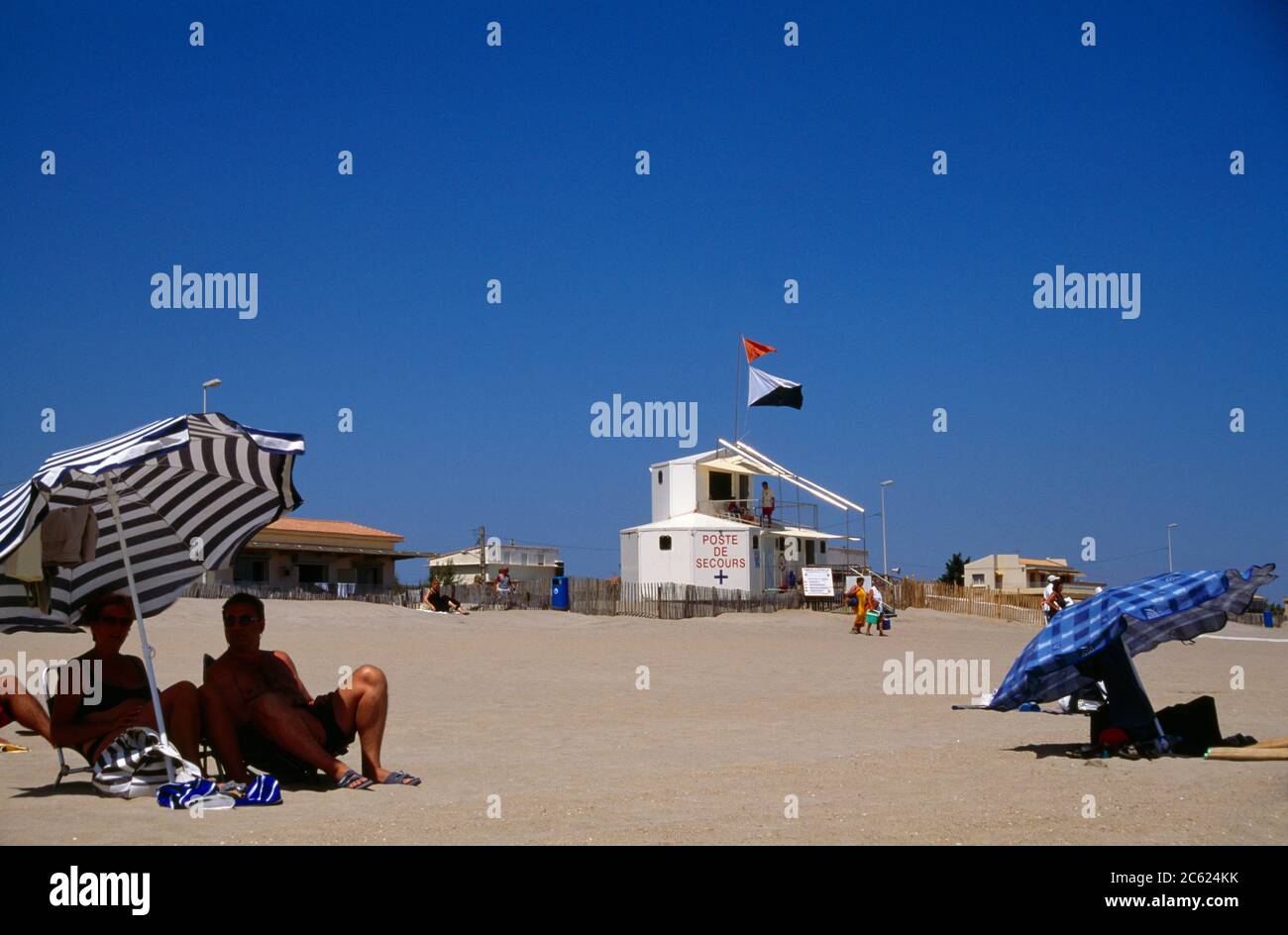 Languedoc Roussillon France Marseillane People Under Parasols On The Beach Poste De Secours (First Aid Post) Stock Photo