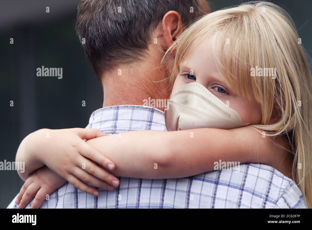 Man carrying child girl in medical face mask Stock Photo