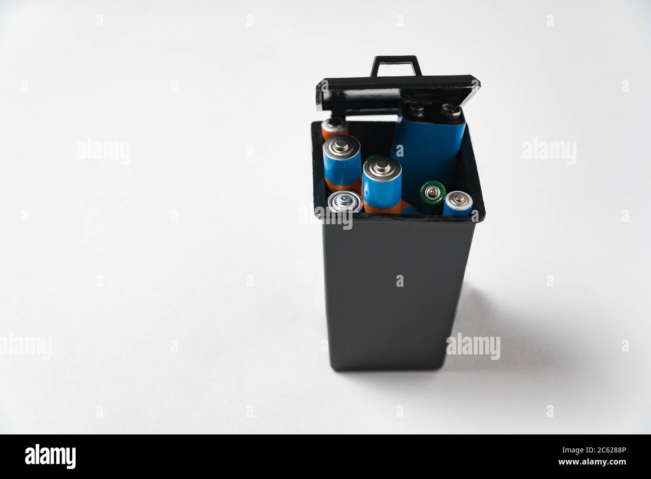 Used batteries in black garbage container on white background. Recycling batteries concept. Stock Photo