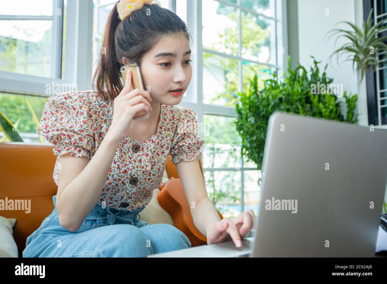 Asian businesswomen are using notebook computers and using a mobile phone for online meetings and working from home Stock Photo