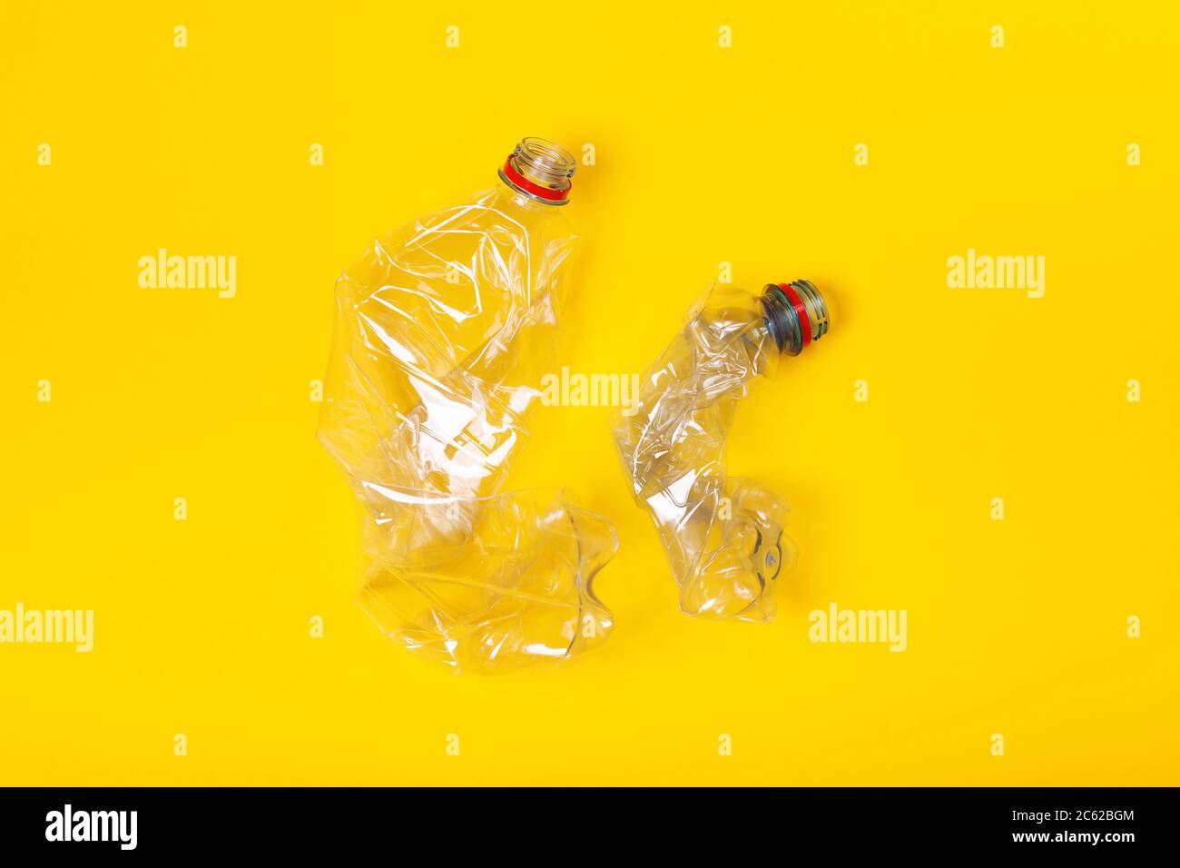 Two used plastic bottles on yellow background. The concept of pollution of the planet and the oceans with plastic waste. Stock Photo
