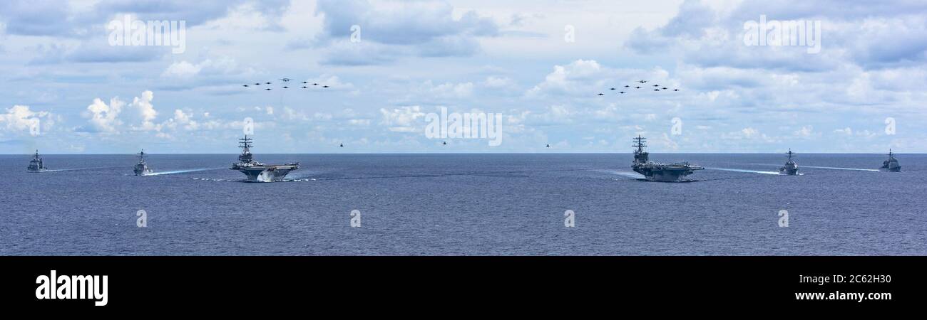 Aircraft from Carrier Air Wing 5 and Carrier Air Wing 17 fly in formation over the Nimitz Carrier Strike Force (CSF) on July 6, 2020. The USS Nimitz (CVN 68) and USS Ronald Reagan (CVN 76) Carrier Strike Groups are conducting dual-carrier operations in the Indo-Pacific as the Nimitz CSF. Rear Adm. George M. Wikoff, commander of the strike group led by the USS Ronald Reagan, stated that 'the purpose is to show an unambiguous signal to our partners and allies that we are committed to regional security and stability.' Photo by MC3 Sarah Christoph/U.S. Credit: UPI/Alamy Live News Stock Photo