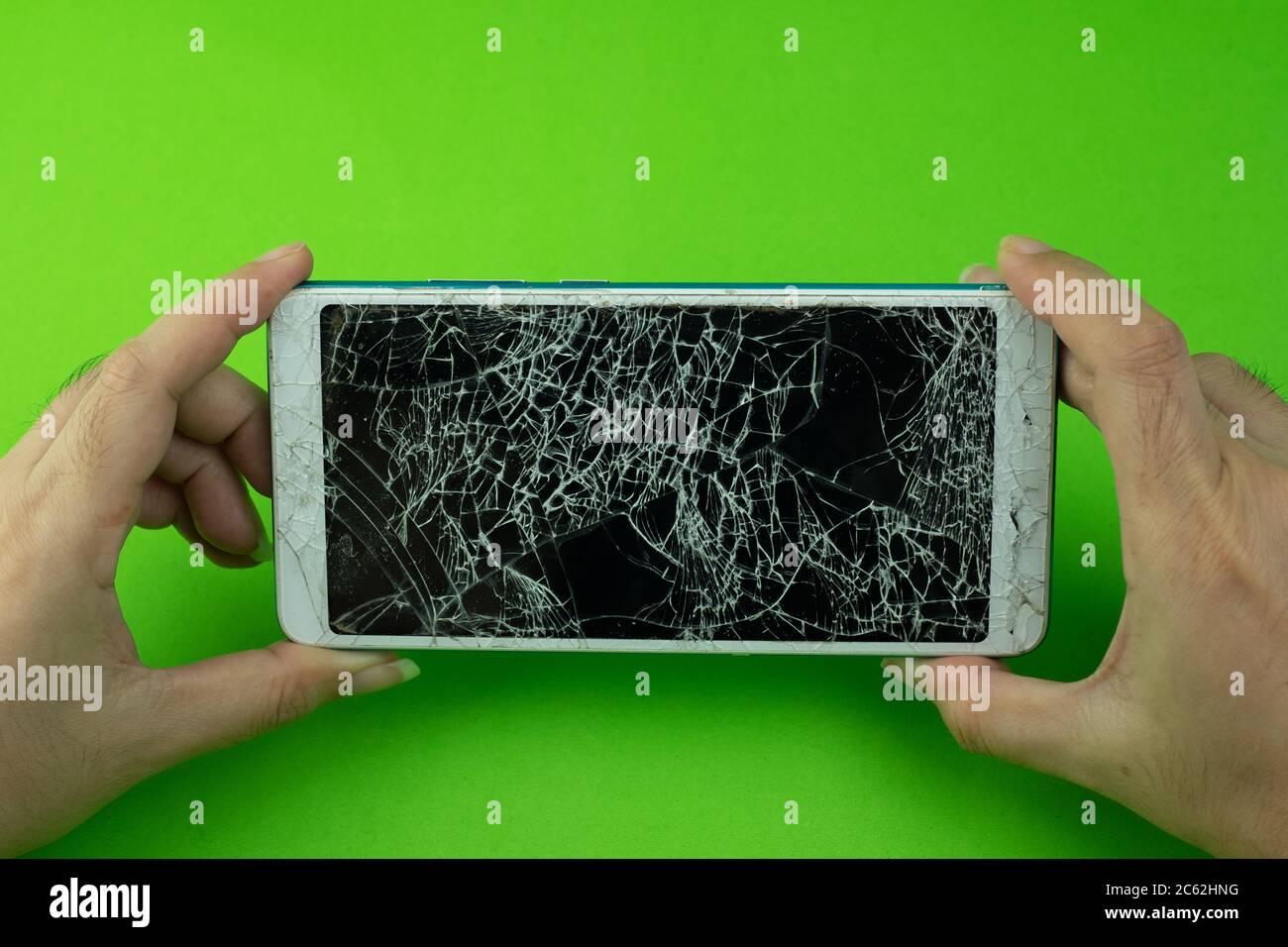 Hand Racked Screen Hand holding smartphone screen is cracked on green background Stock ...