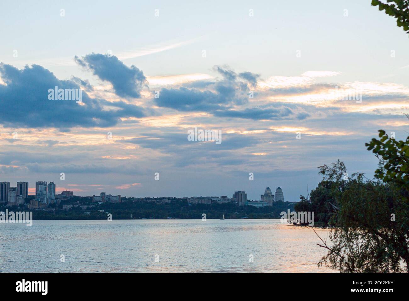 City view. River at sunset. Colorful sky with clouds. Cityscape ...