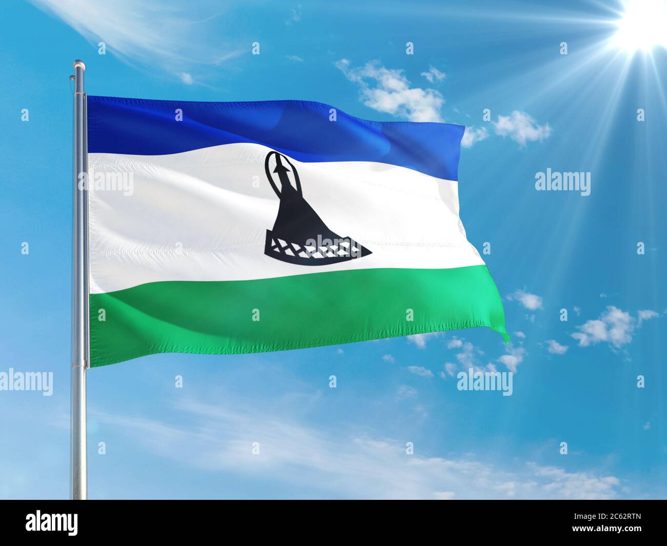 Lesotho national flag waving in the wind against deep blue sky. High ...