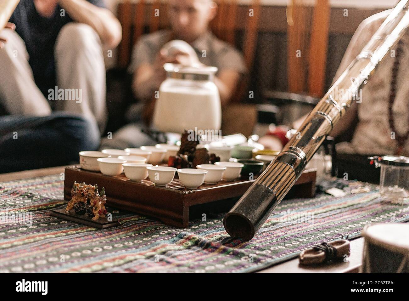 the tea ceremony is conducted by a tea master. tea party in the style of boho, hippie. tea cups on a special wooden coffee table. Preparation of masal Stock Photo