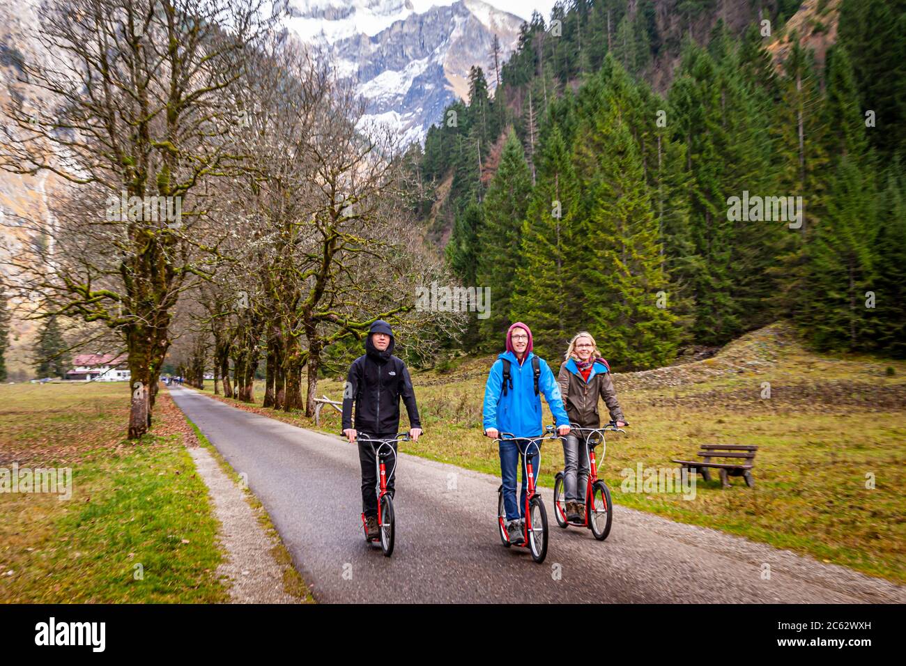 After the easy hike along the river Oy from Oberstdorf to the inn, the asphalted way back is best done with rental scooters. Oberstdorf, Germany Stock Photo