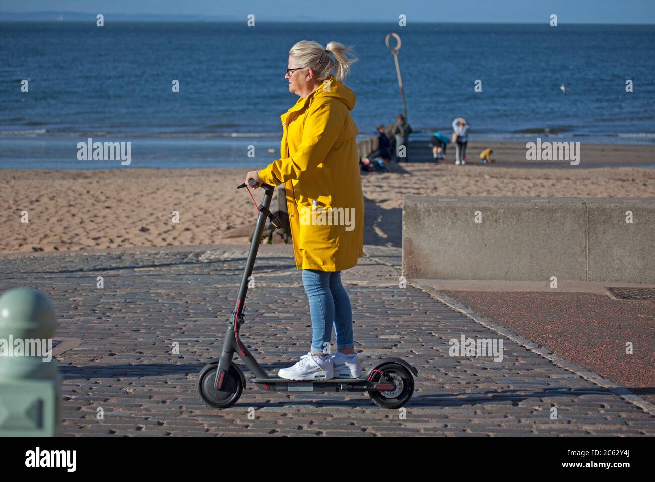 Portobello, Edinburgh, Scotland, UK. People of Porty find various ways to  move around, some swim, some skate and it appears the older generation are  embracing the new electric powered scooters, which of