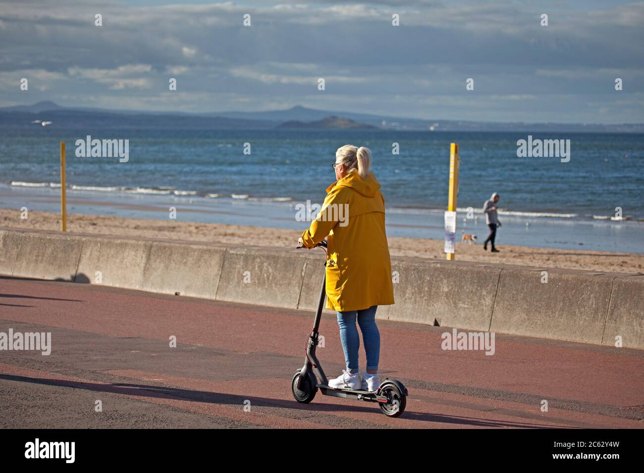 Portobello, Edinburgh, Scotland, UK. People of Porty find various ways to  move around, some swim, some skate and it appears the older generation are  embracing the new electric powered scooters, which of