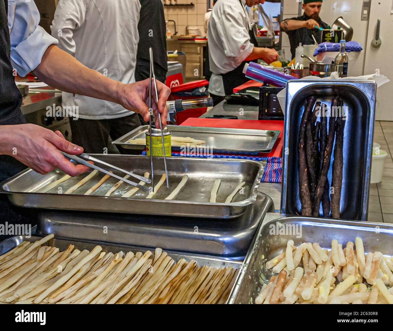 Black salsify preparation in the kitchen by Marco Müller. Three state forms promise variety with this often underestimated vegetable. Michelin Star Chef Marco Müller in Sankt Peter-Ording, Germany Stock Photo