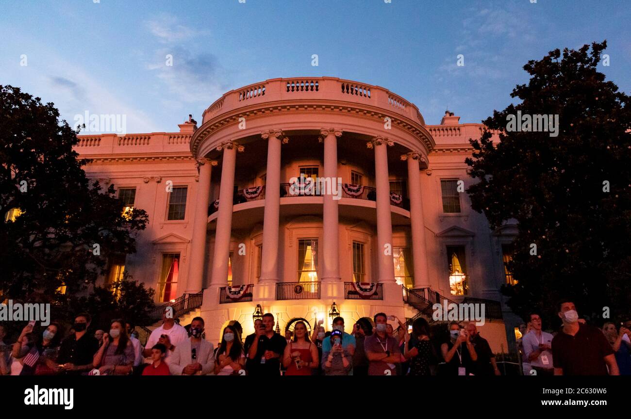 Guests watch the fireworks explode over the National Mall during the annual Independence Day celebration on the South Lawn of the White House July 4, 2020 in Washington, DC. Stock Photo