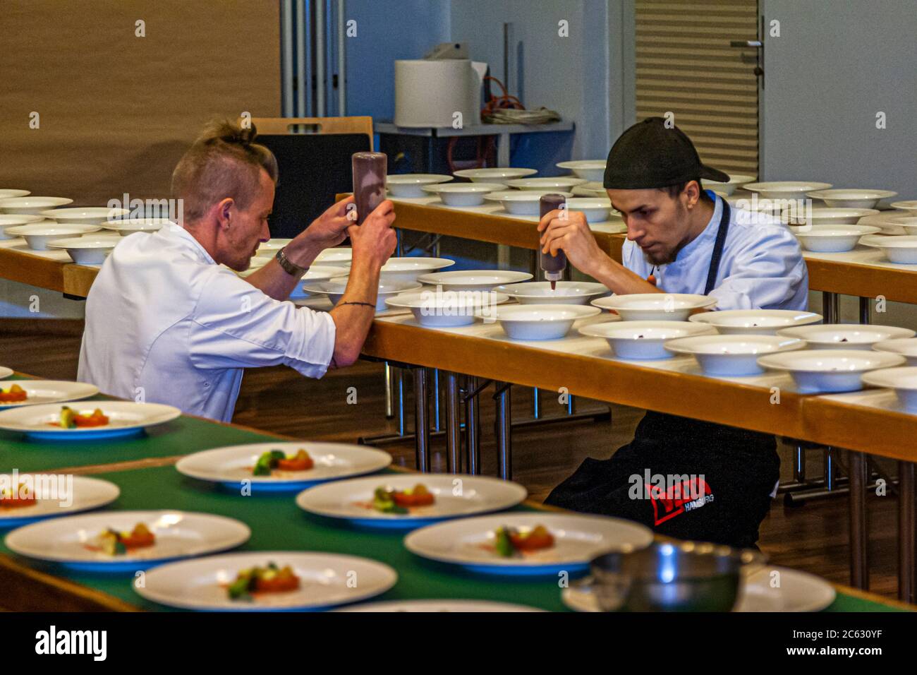 Two chefs from Michelin Star Chef Marco Müller's team dress the plates at the Schleswig-Holstein Gourmet Festival in Sankt Peter-Ording, Germany Stock Photo