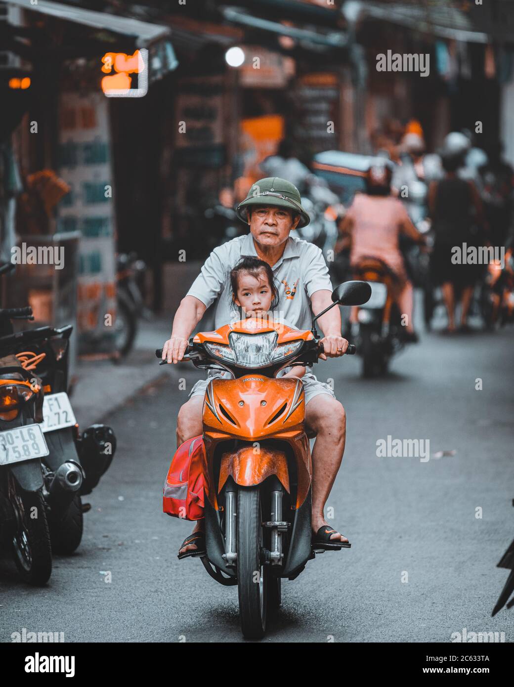 Hanoi, Vietnam - 18th October 209: A father drives daughter to school on a moped in the streets of Hanoi Stock Photo