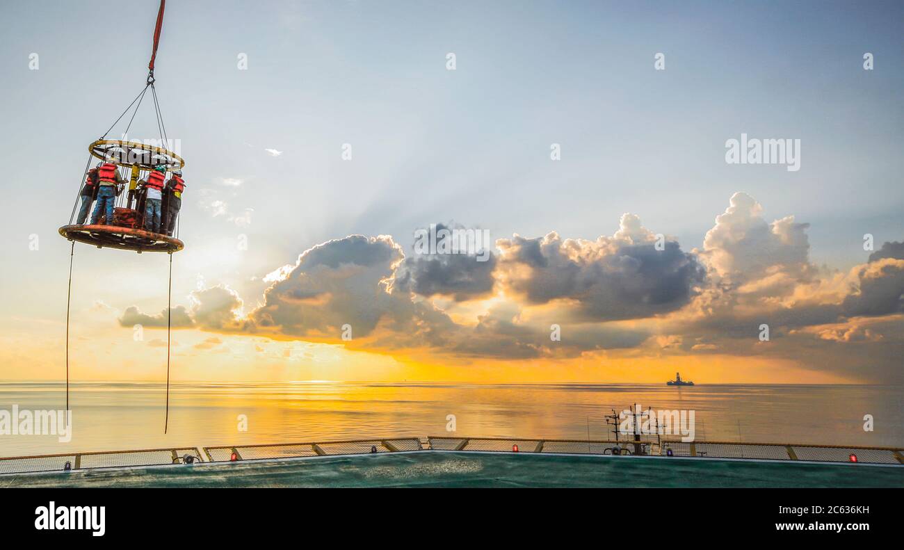 Crew change from offshore platform to waiting ship (out of frame) Stock Photo