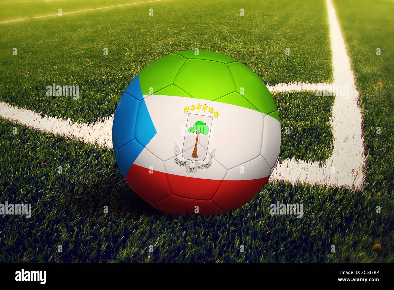Equatorial Guinea flag on ball at corner kick position, soccer field background. National football theme on green grass. Stock Photo