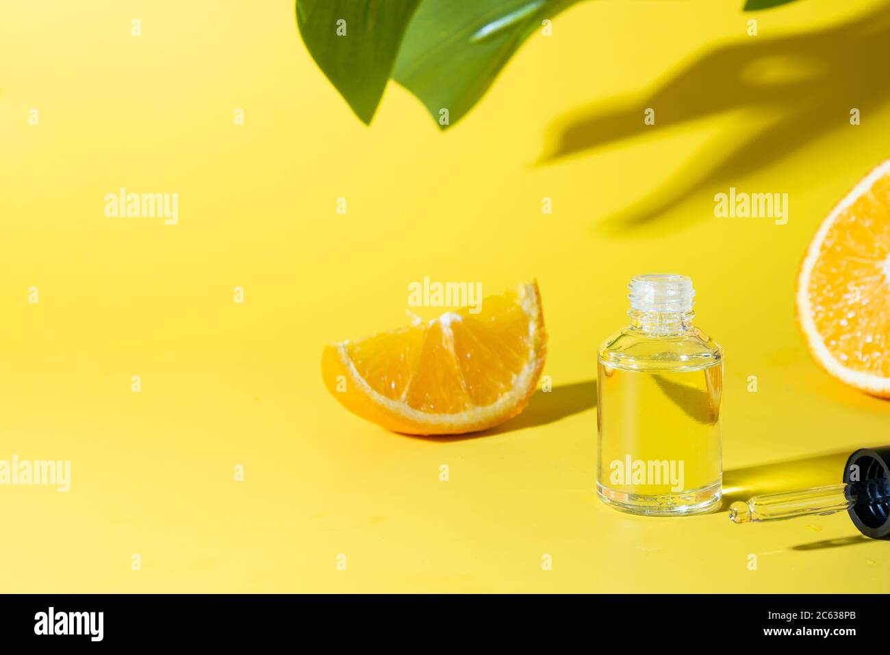 Cosmetic hyaluronic acid or hydrating oil and orange essence on yellow background. Close up. Anti-cellulit care. Stock Photo