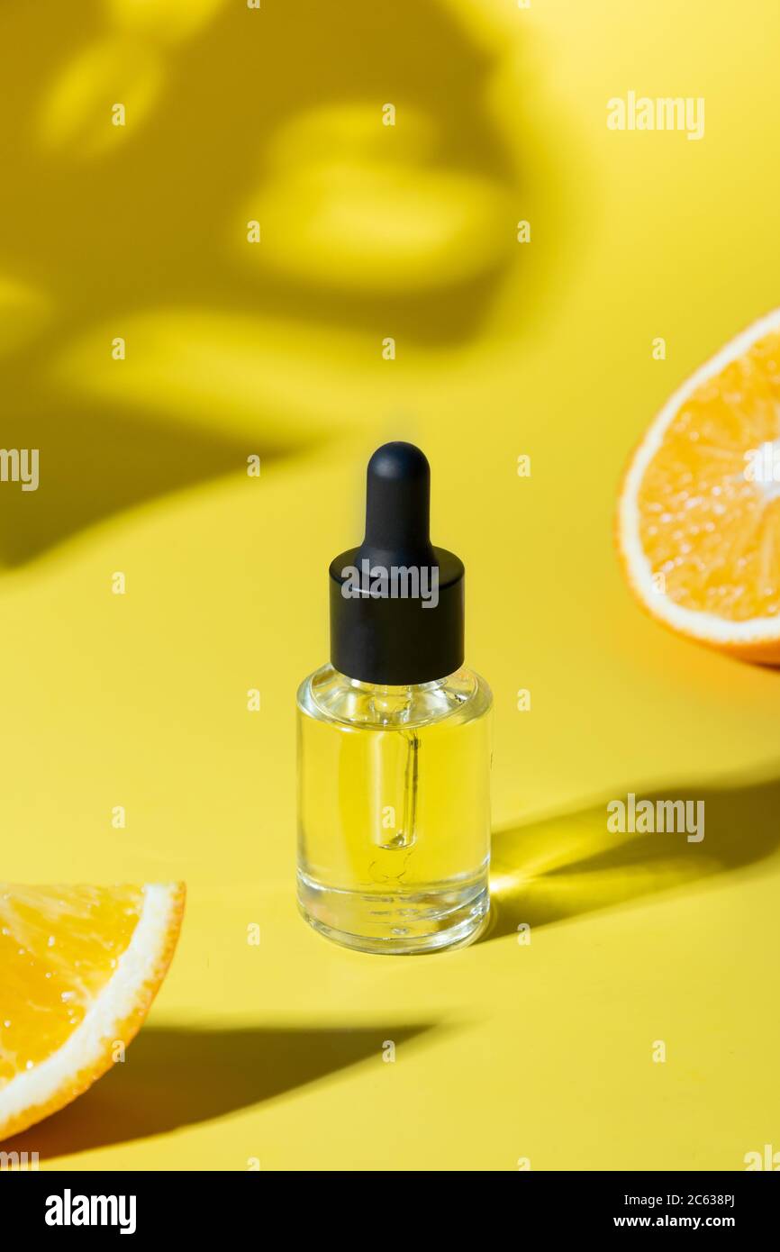 Cosmetic hyaluronic acid or hydrating oil and orange essence on yellow. Close up. Anti-cellulit care. Stock Photo