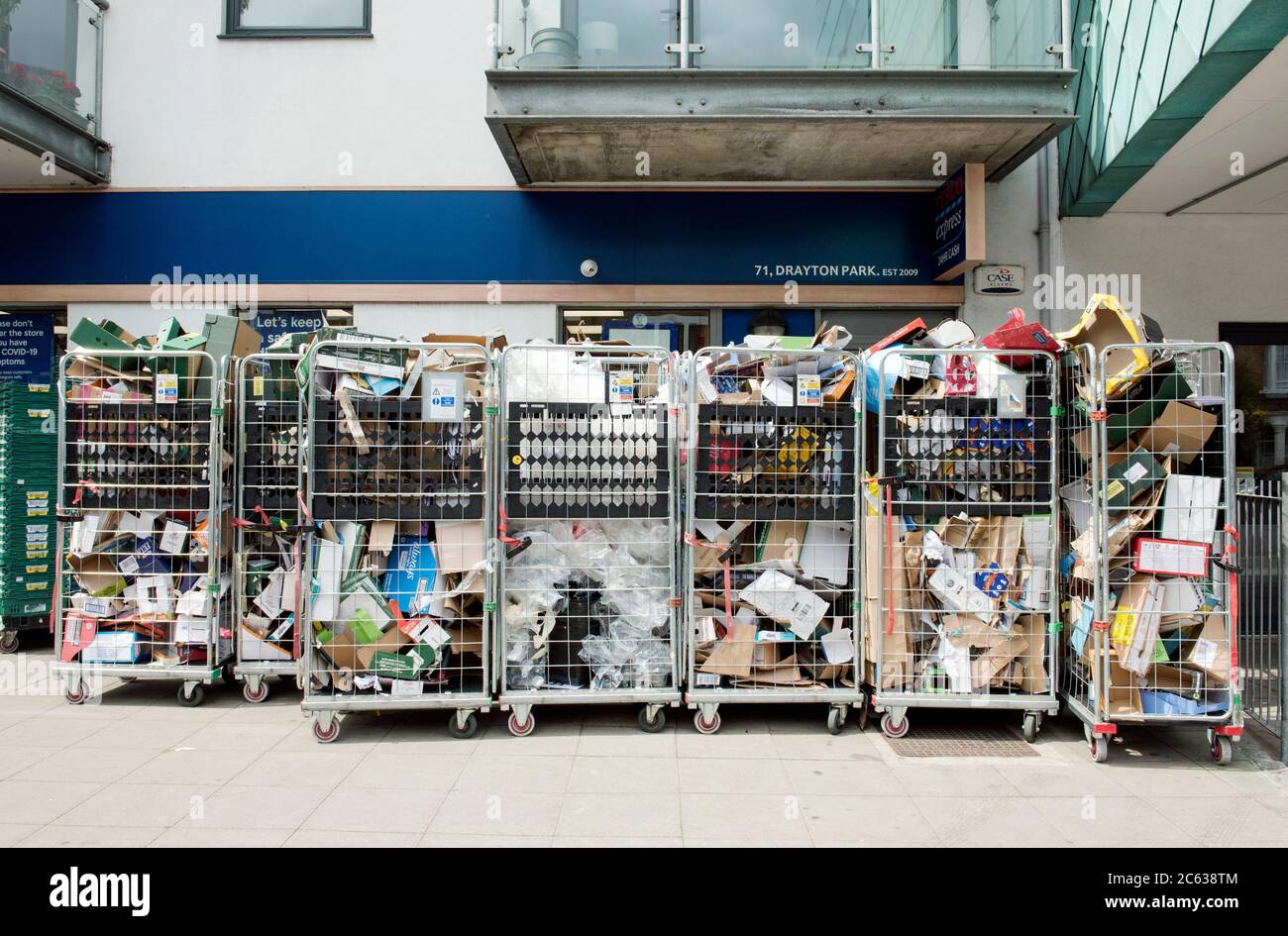 Recyclable Cardboard boxes in roll cages or wire trollies outside supermarket waiting to be collected for recycling Drayton Park Highbury Islington Stock Photo