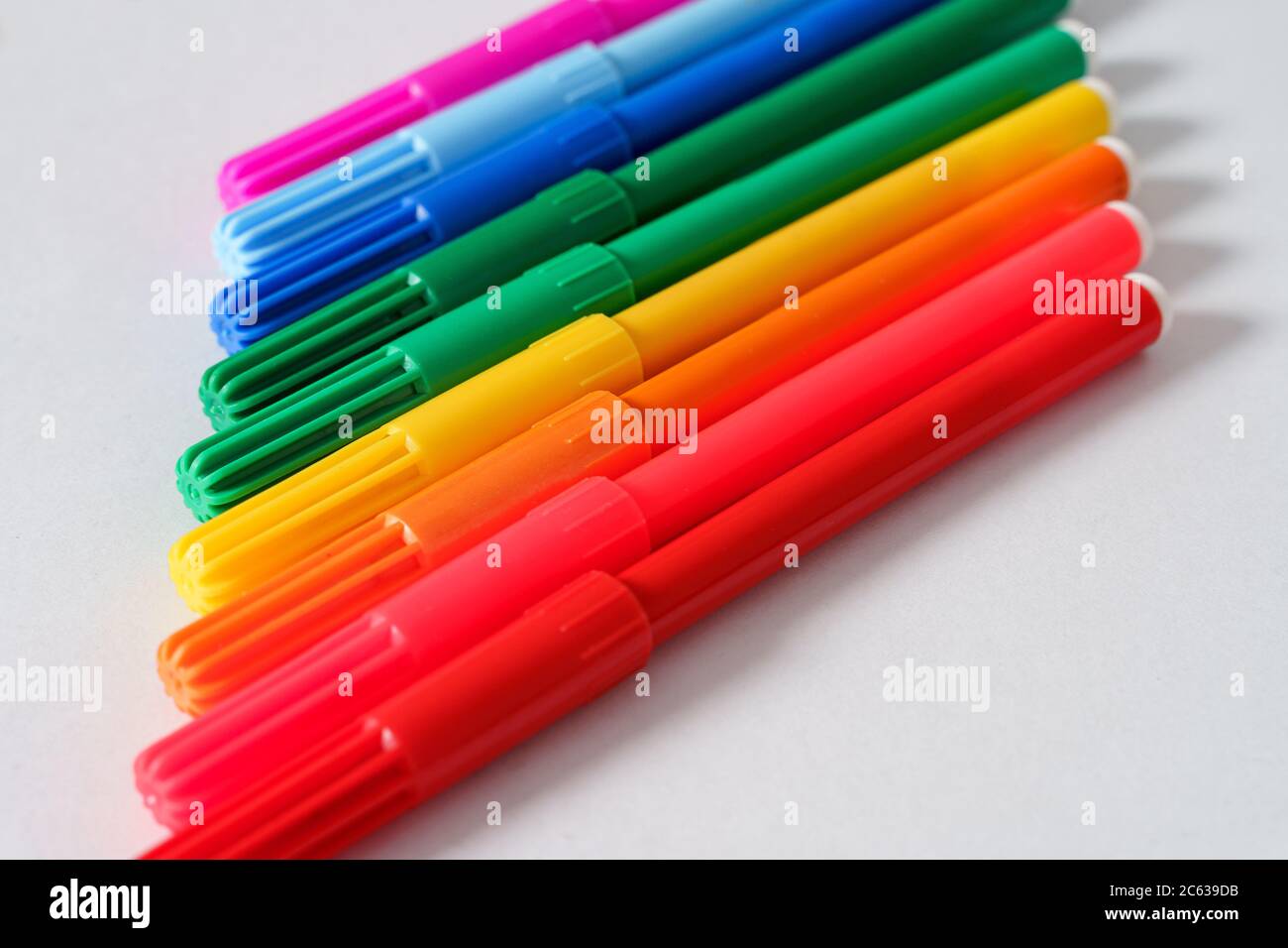 Colored markers on a white sheet. Stock Photo