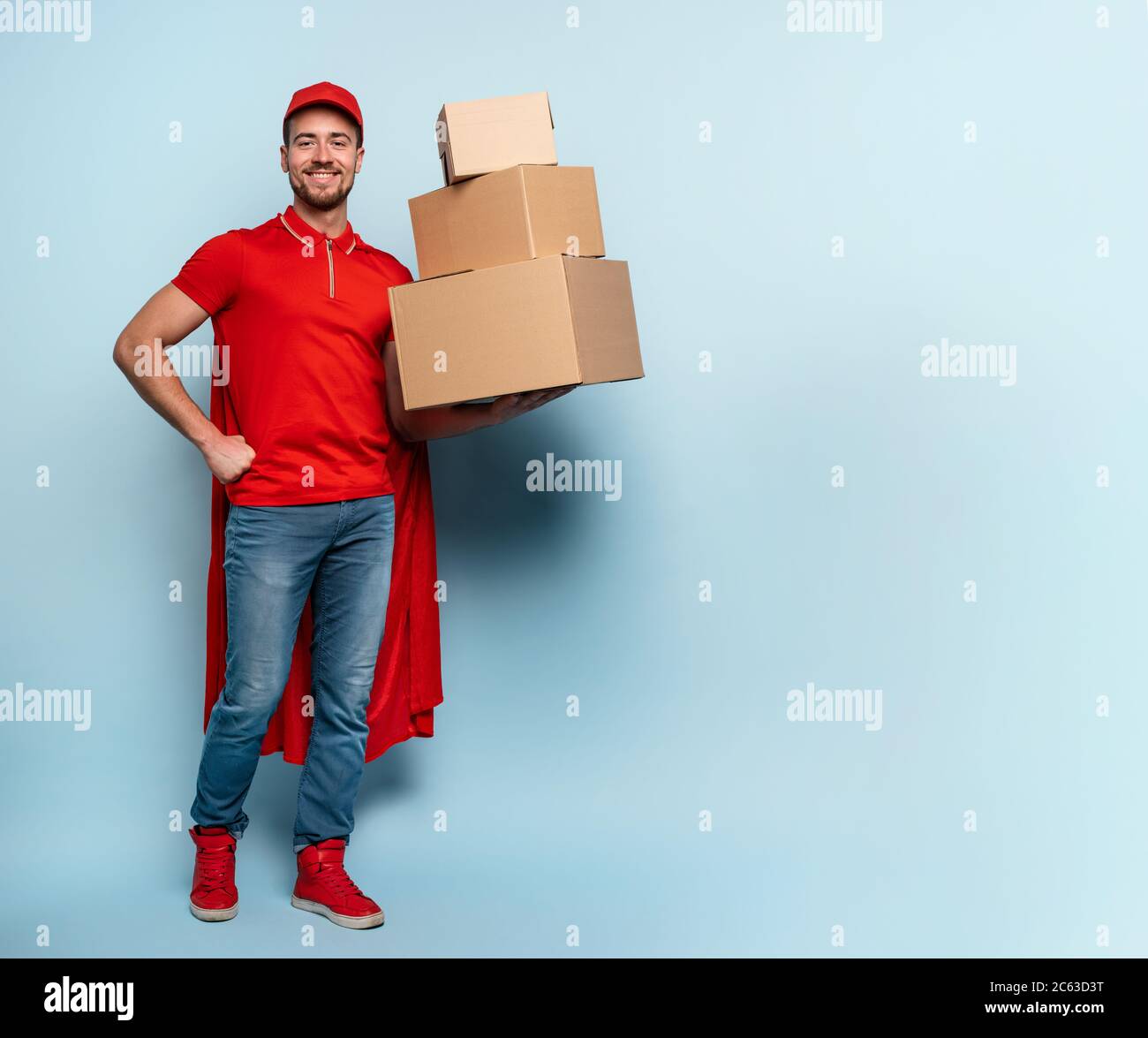 Courier has a lot of boxes to delivery. Emotional expression. Cyan background Stock Photo