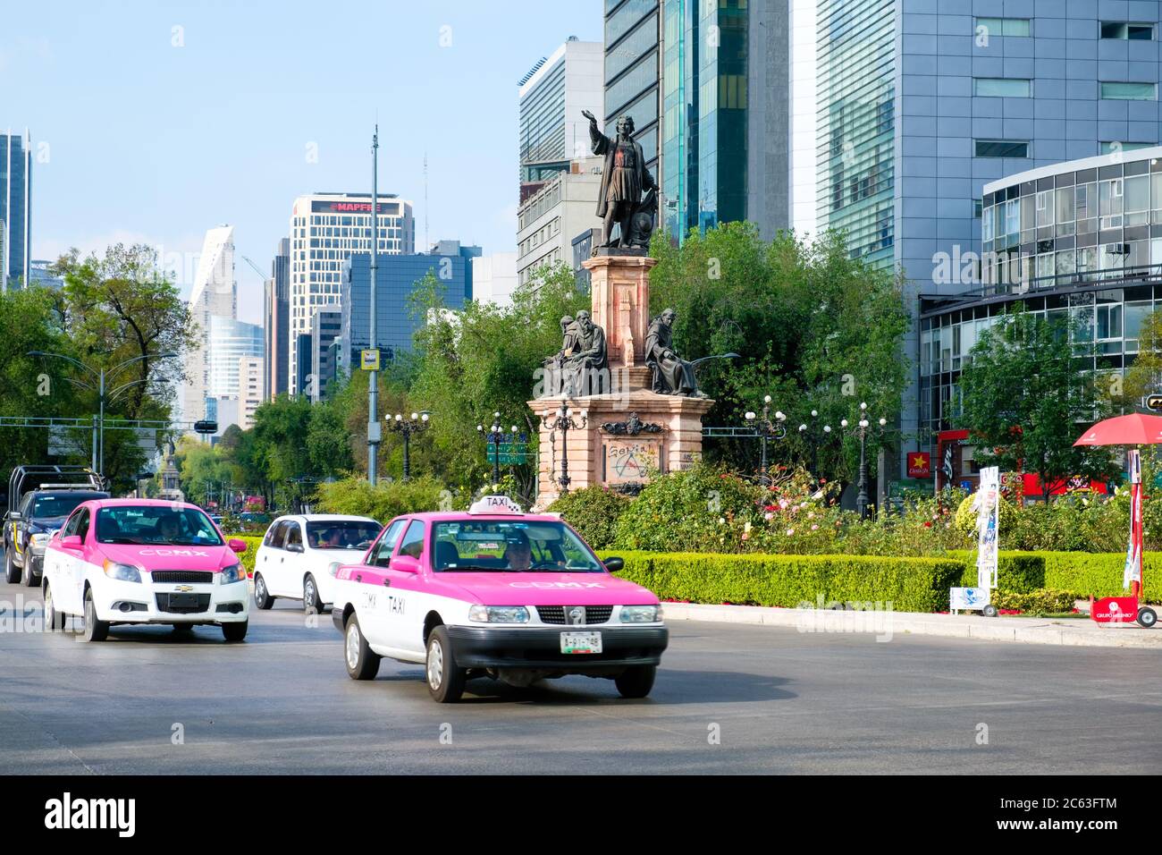 Street scene with typical pink taxis next to the Columbus Monument at Paseo de la Reforma in Mexico City Stock Photo