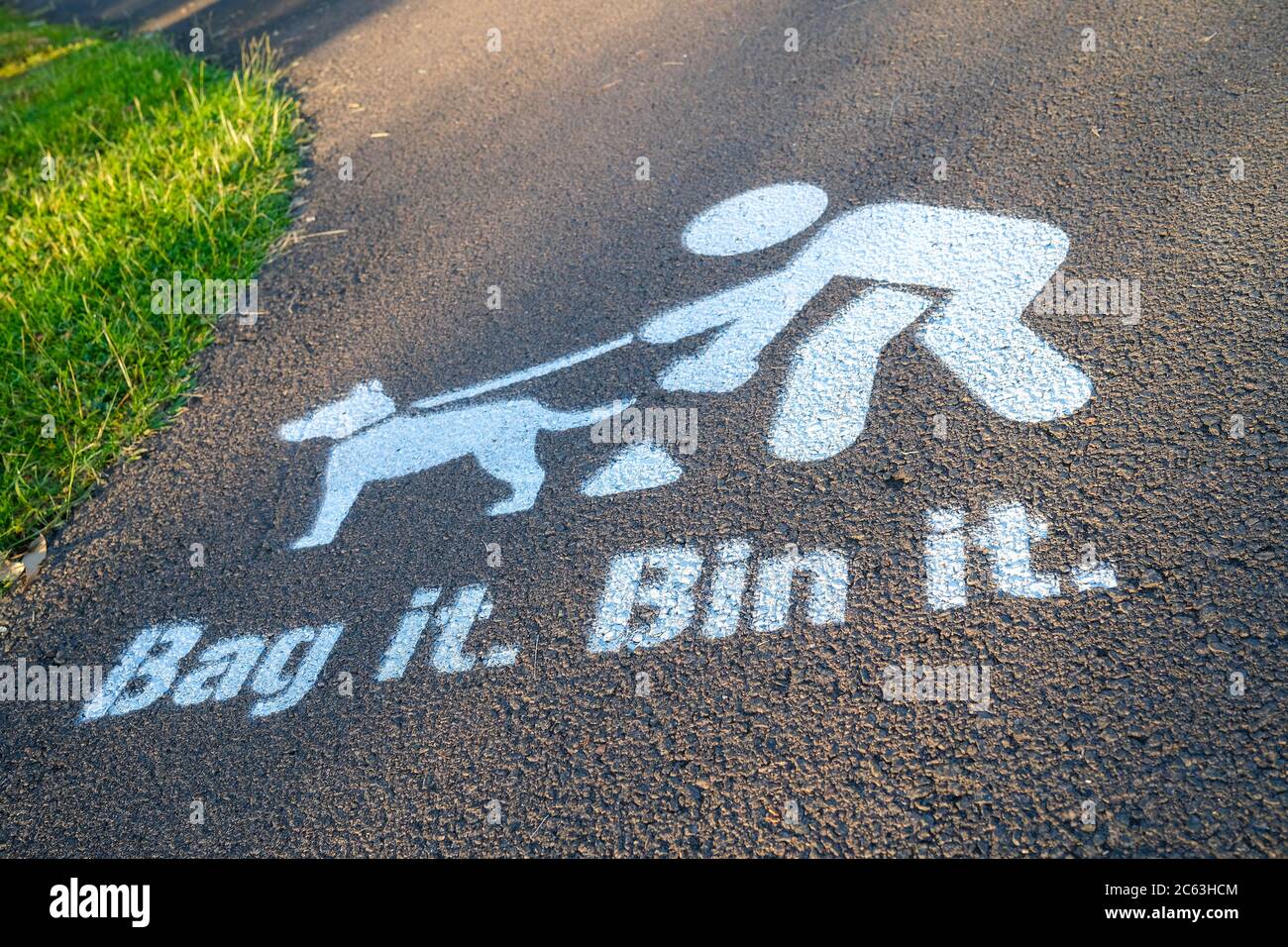 Bag it Bin it painted sign on footpath, encouraging dogs owners to clear up after their pet Stock Photo