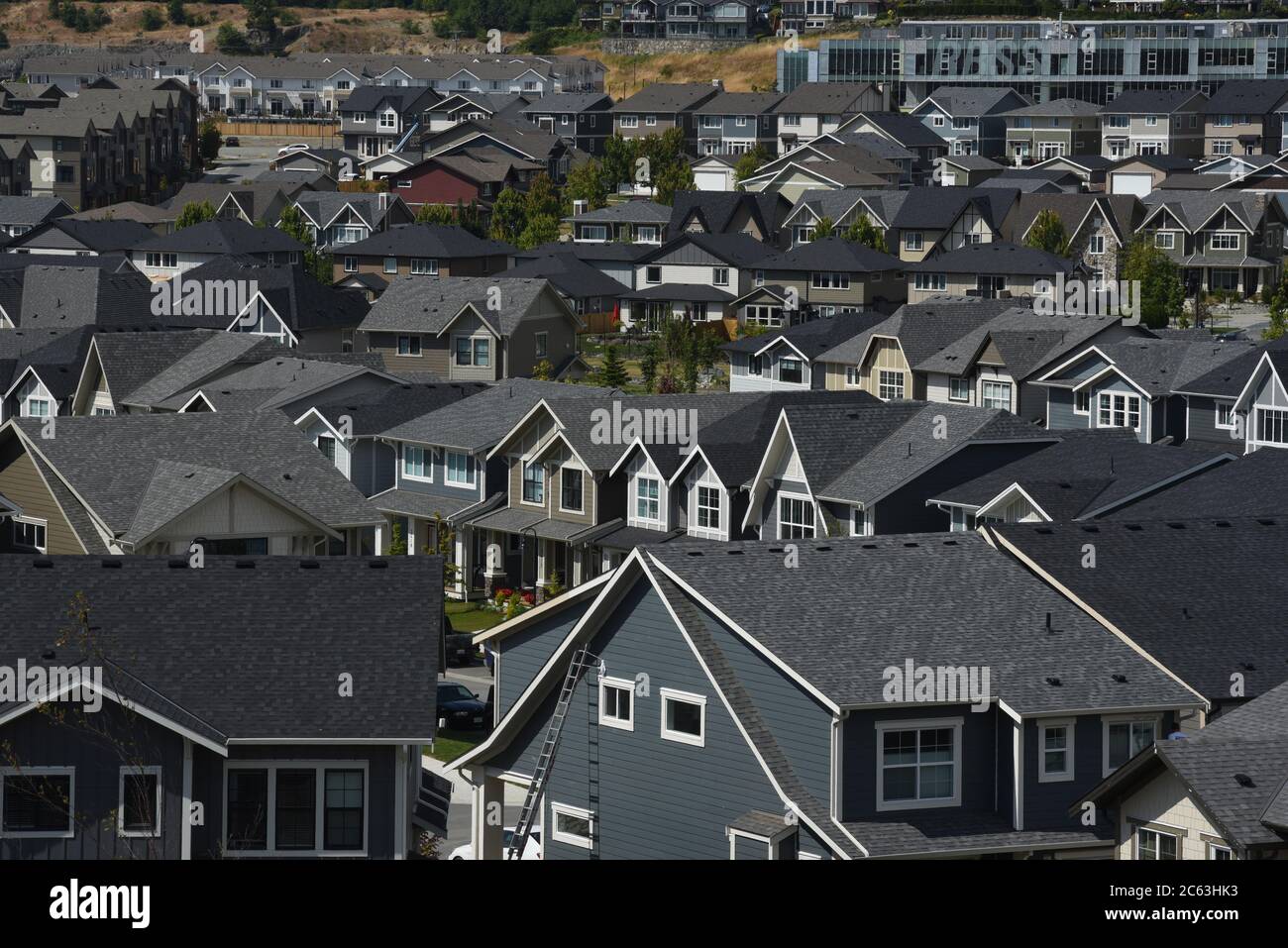 Houses crowd the streets of the Royal Bay development in Colwood, British Columbia, Canada. At top right is Royal Bay Secondary School. Colwood is a s Stock Photo