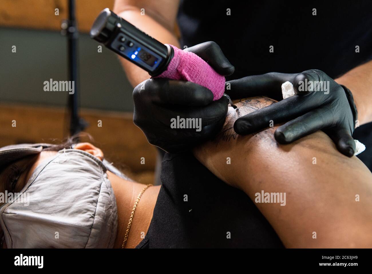 Tattoo artist Ed of 6 Skulls NYC tattoes a lion head on the arm of a client wearing a face mask as New York City enters Phase 3 of the Coronavirus opening on July 6, 2020, in New York City. (Photo by Gabriele Holtermann/Sipa USA) Credit: Sipa USA/Alamy Live News Stock Photo