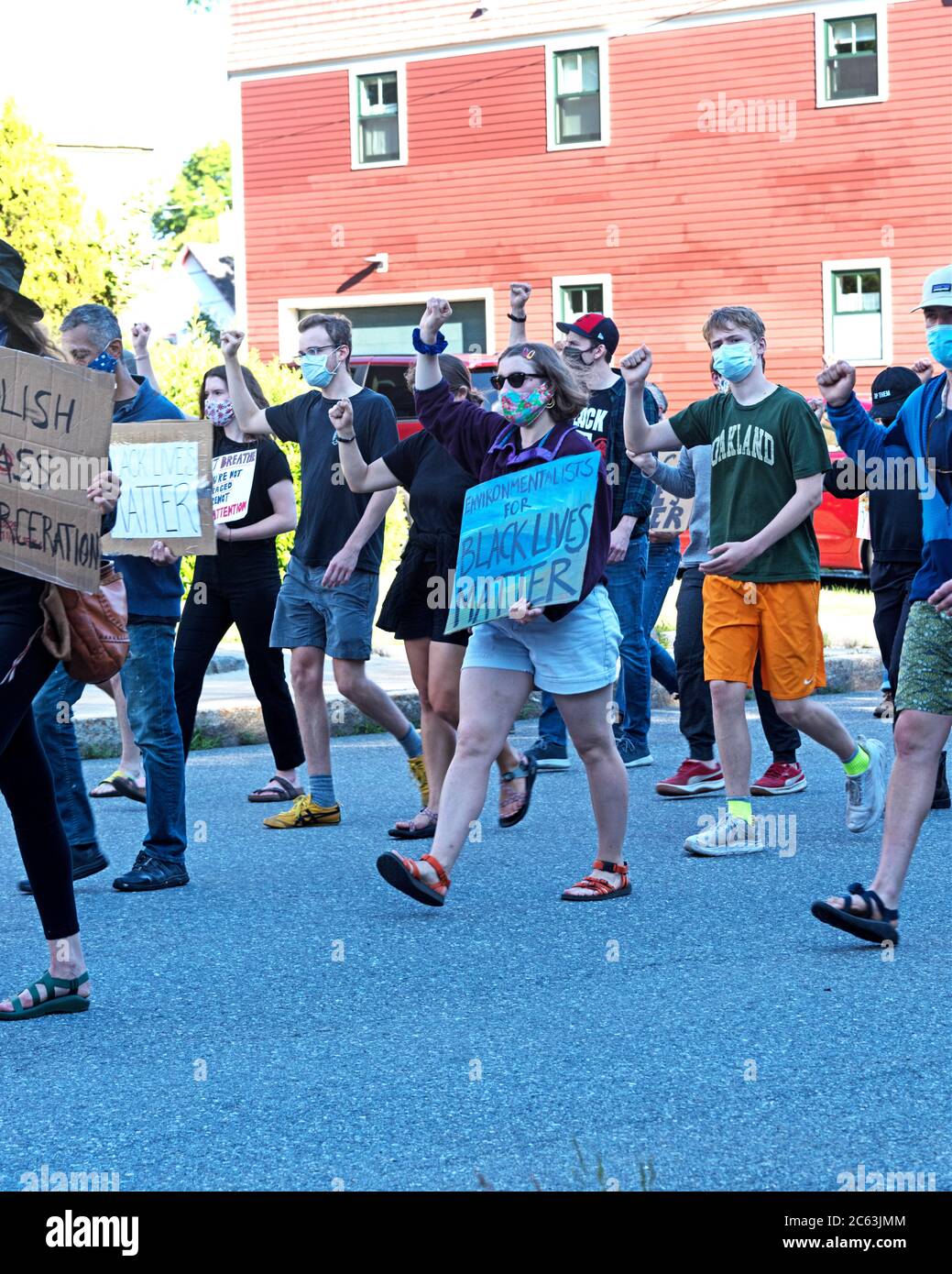 Bar Harbor, Maine, USA. 06 July, 2020. Marchers in a protest led by the Mount Desert Island Racial Justice Collective walk silently down Ledgelawn Avenue with a fist raised in support of Black Lives Matter. ©Jennifer Booher/Alamy Live News Stock Photo