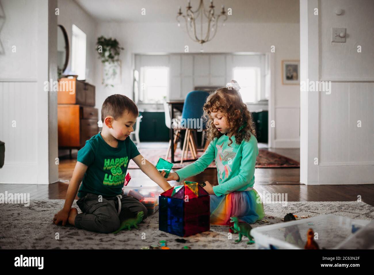 Brother and sister playing with magnetic tiles in living room Stock Photo
