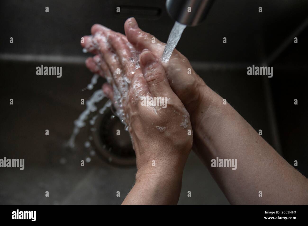 Close up of someone rinsing hands in the sink Stock Photo