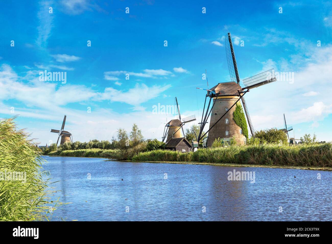 Windmills And Water Canal In Kinderdijk In A Beautiful Summer Day Windmills And Water Canal In Kinderdijk In A Beautiful Summer Day