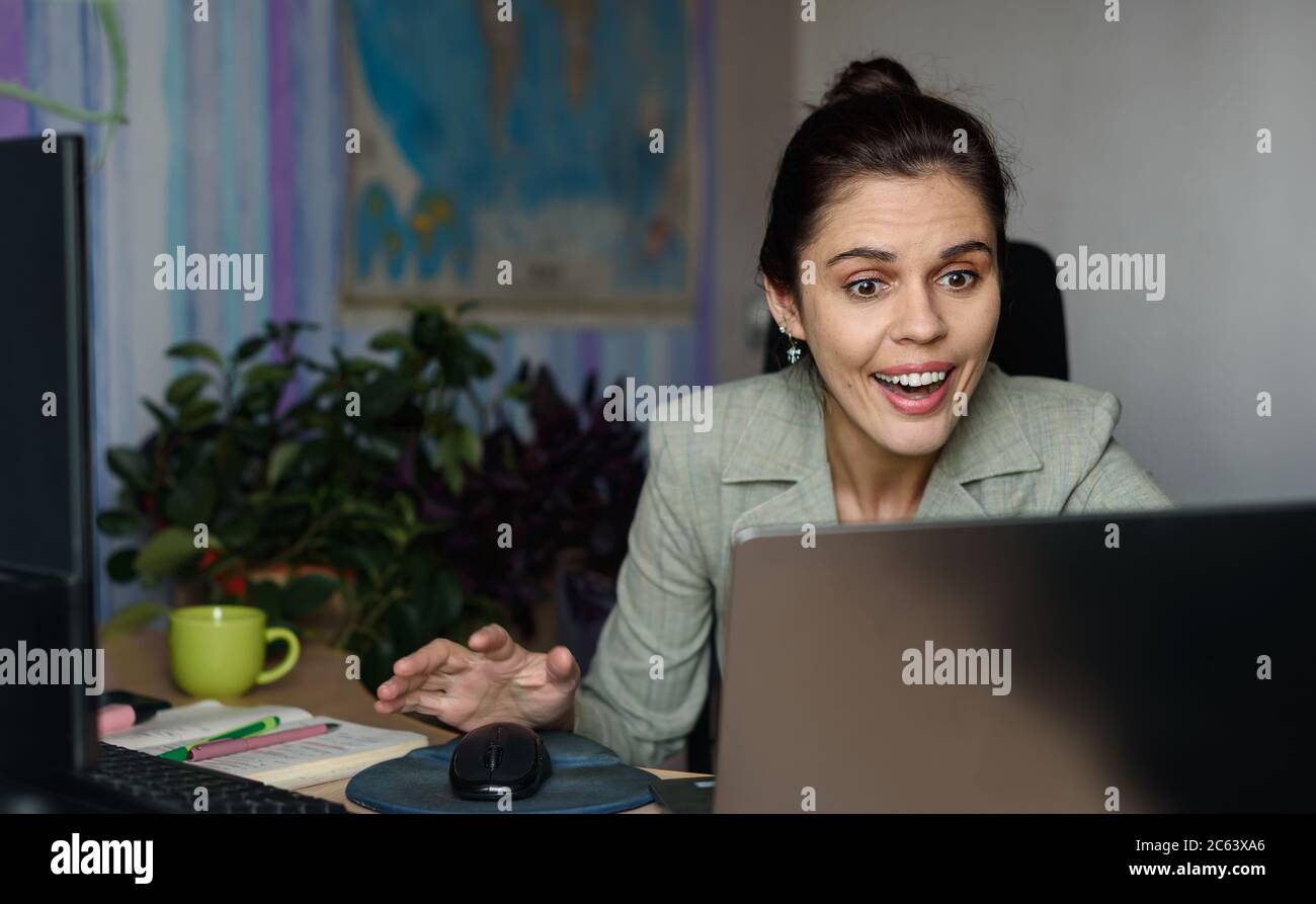Shocked business woman using laptop looking at computer screen at home office. Human face expression, emotion, feeling, perception, body language Stock Photo