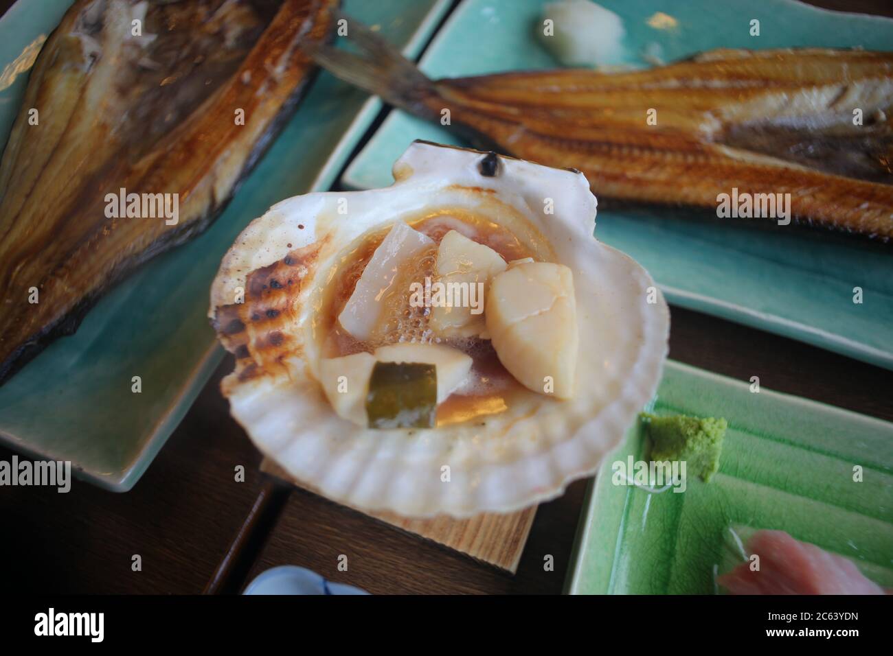 Scallop or hotate placed on the shell and grilled over a small oven Is