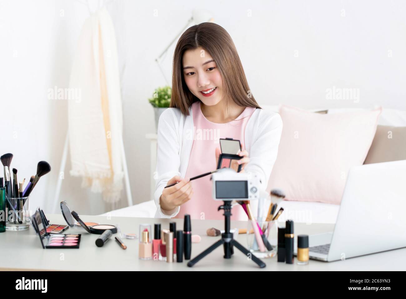 Beautiful Asian beauty vlogger doing product review live broadcasting in front of camera at home Stock Photo